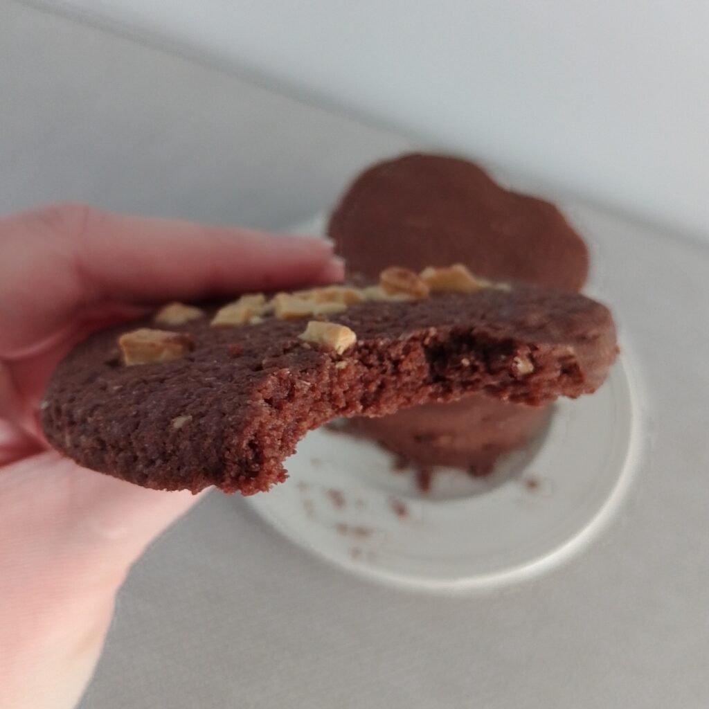 in de hand een glutenvrij koekje waar een hapje uit is